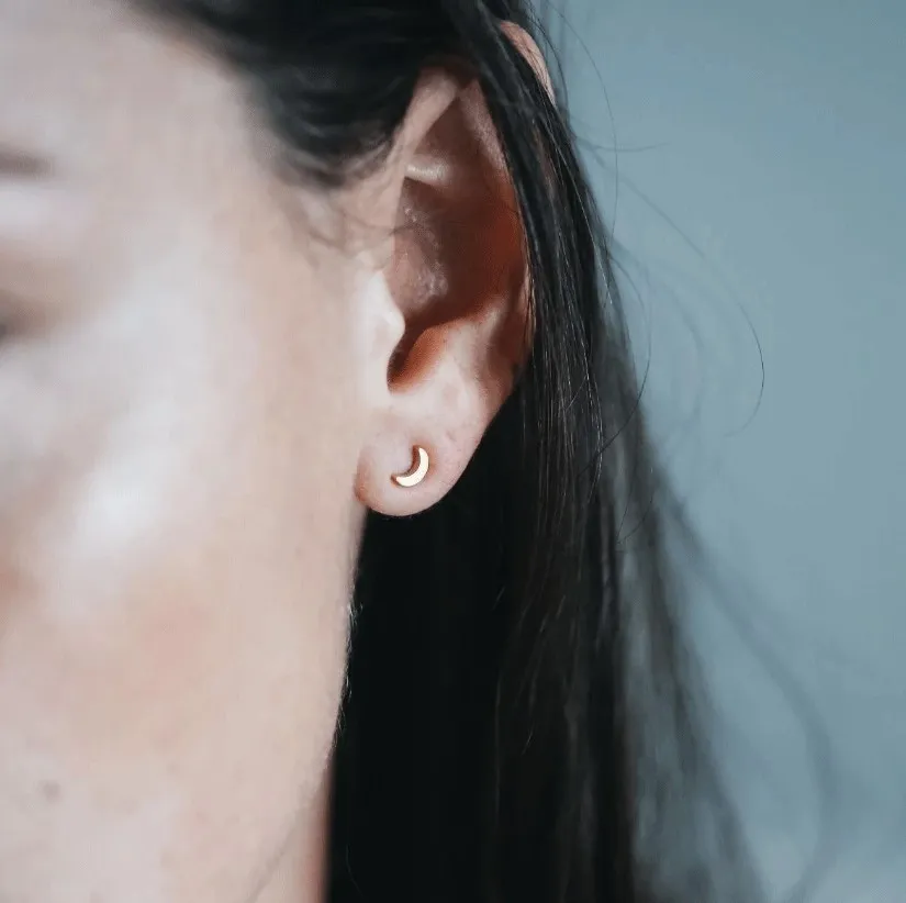 NÆRBILD AV EDBLAD MÅNE STUDS BRIGHT NIGHT GULL BLITT AV EN MODELL