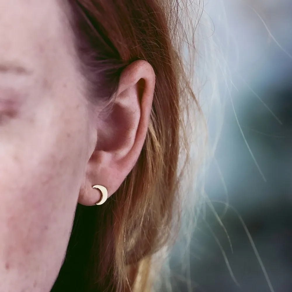 NÆRBILD AV EDBLAD MÅNE STUDS BRIGHT NIGHT GULL BLITT AV EN MODELL