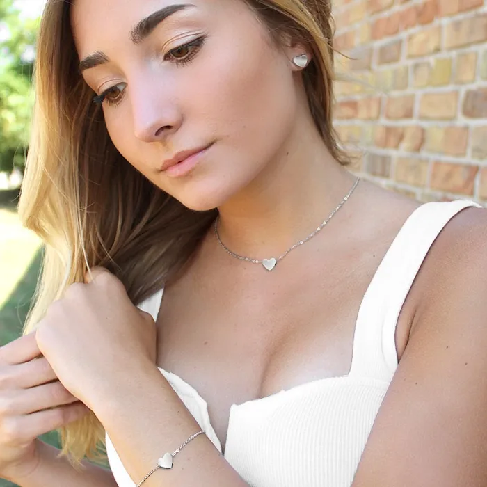 EDBLAD PURE HEART STUDDER GULL båret på øret med kjede og armbånd