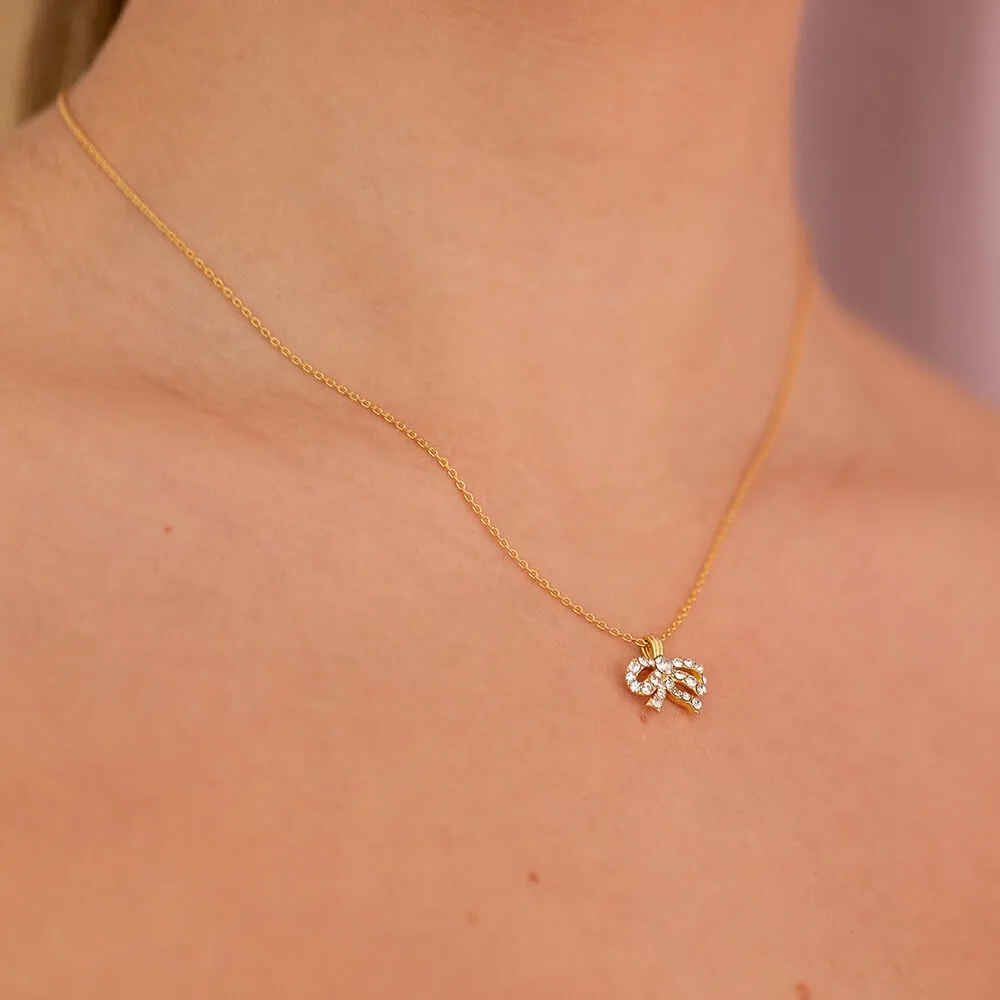 PETITE ANTOINETTE BOW NECKLACE GOLD BÅRET AV EN MODELL