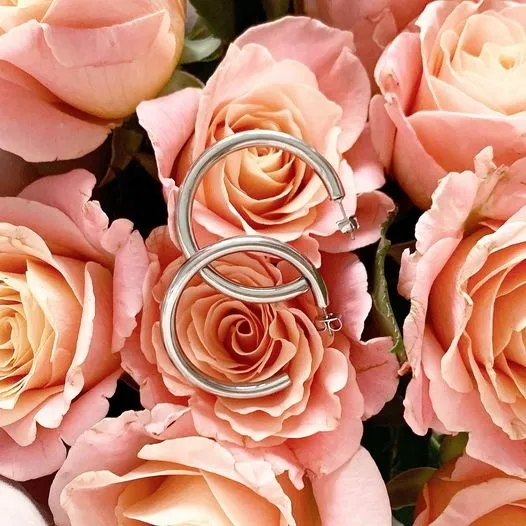 STILIGE SØLVHOOPS PRESENTERT I EN LIVSSTILINNSTILLING MED ROSA TILBEHØR