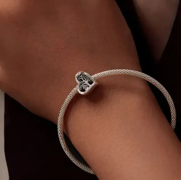 JBX CHARM TREE OF LIFE SILVER PÅ ET ARMBÅND PÅ EN MODELLS HÅNDLEDD